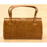 A circa 1950s tan coloured Crocodile skin handbag by Fassbender,