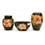 A Moorcroft ginger jar with cover, green ground, peach coloured hibiscus flower,