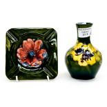 A Moorcroft green ground ashtray with anemone flower, together with a squat vase,