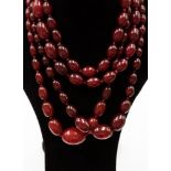 Three strands of cherry amber type beads in various graduated sizes of oval beads with 9ct gold