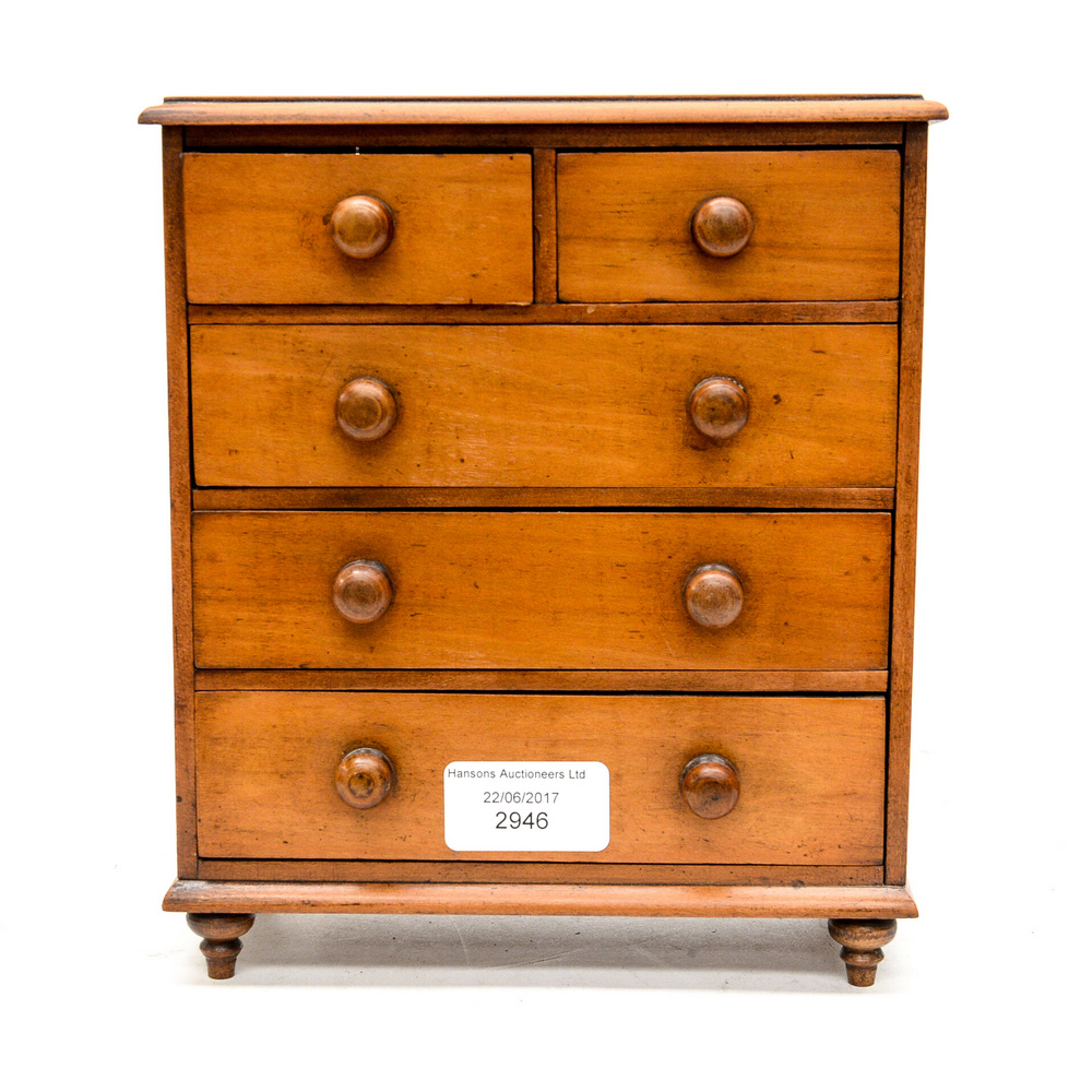 A set of miniature 19th Century chest of drawers (three long and two short drawers) stained boxwood