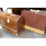 A early 20th Century Oak cased Singer Sewing Machine and another leather cased Singer sewing