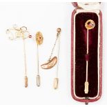 A collection of four stick pins comprising of Edwardian stick pin star set with ruby and floral