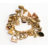 A 15ct gold charm bracelet containing a collection of twenty six assorted hardstone seal charms,