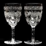 A pair of late 19th century clear wine glasses, the bowls etched with vines, facet cut stems,