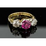 A ruby and diamond three stone 18ct gold ring, the central round mixed cut ruby of approximately 6.