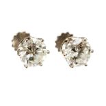 A pair of diamond solitaire white gold stud earrings,