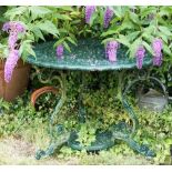 A cast iron table, fretted foliate top, painted green,