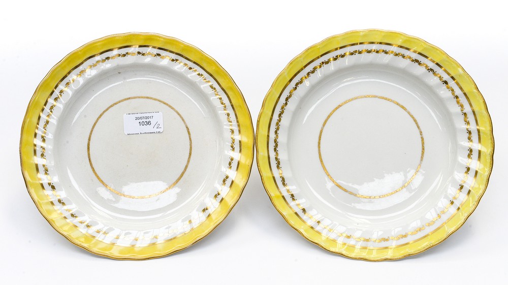 Two Derby twist fluted edge plates with a yellow band and gilt borders, Exhibition label on reverse,