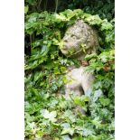 A stone figure putto on rocky outcrop on plinth