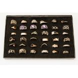 A tray of thirty six assorted silver and white metal rings to include stone set,