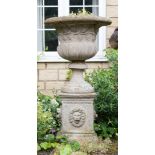 A stone pedestal vase on plinth,