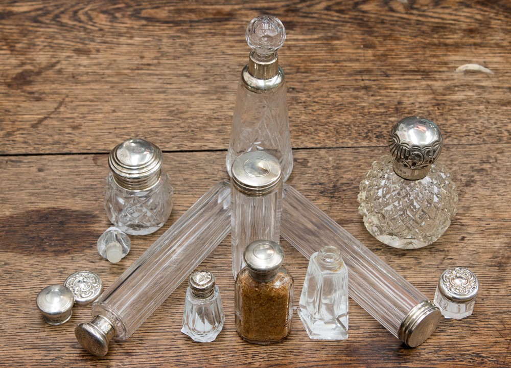 A group of ten silver topped perfume and dressing table bottles, including faceted glass,