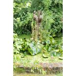 A stone fountain column in the form of three storks