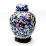 A large Chinese blue ground ginger jar and cover on hardwood stand