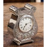 An Edward VII Art Nouveau silver cased mantel clock, embossed floral tendrils,