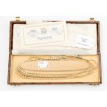 A boxed three strand necklace of faux pearls by Lotus in original box