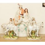 A pair of Staffordshire riding figures and a clock figure group