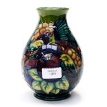 A Moorcroft vase depicting birds, plums and grapes, with blue, green and purple palette, WM to base,