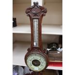An early 20th Century oak cased barometer and thermometer,
