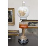 A Victorian oil lamp, having ebonized base, brass pedestal,