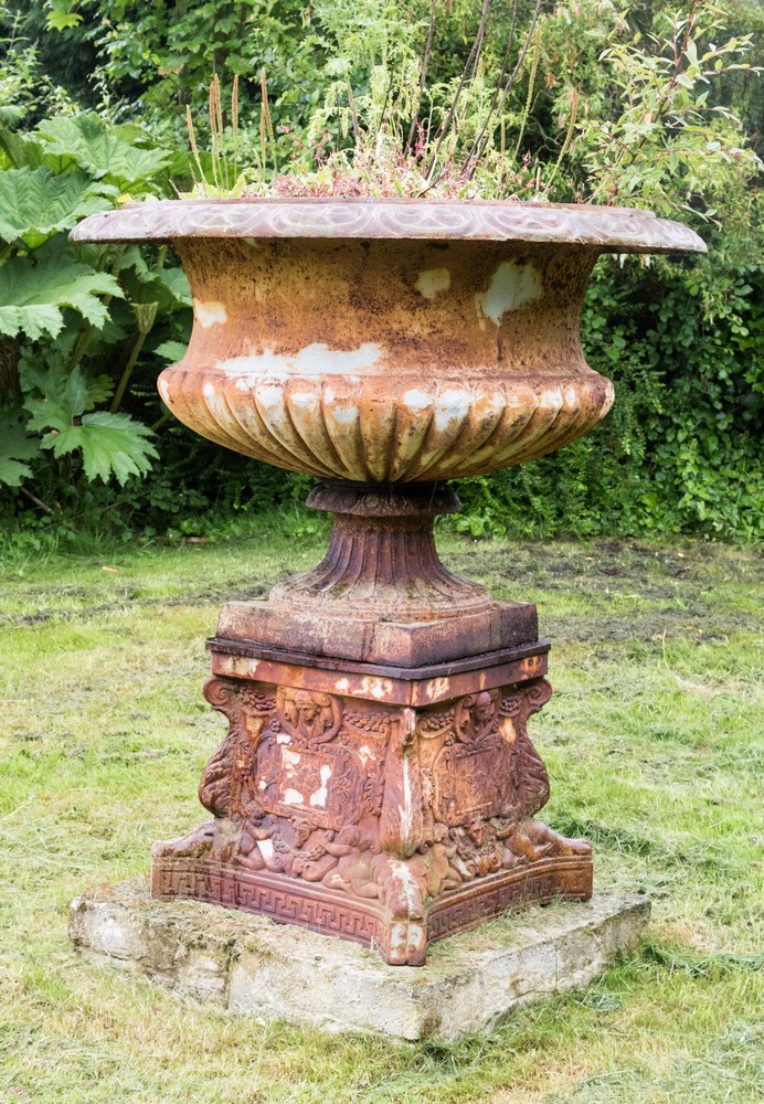 A cast iron Campana urn planter and plinth