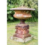 A cast iron Campana urn planter and plinth