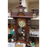 A Victorian wall clock with pendulum and key in working order