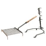 An 'antique' wrought iron standing fire grill, fitted with a turned wooden handle,