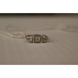 An Art Deco square cut graduated three stone diamond ring, the centre diamond measuring approx 0.