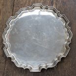 A 20th century pie crust edge silver salver raised on scroll feet, weight approx 28ozt,