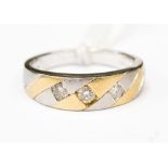 A striking diamond set three stone yellow and white 14ct gold band ring,