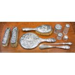 An Edwardian silver dressing table set, Reynolds Angels design, including silver topped jars,