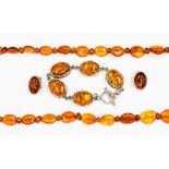 An amber graduated bead necklace together with a bracelet and pair of earrings stamped .