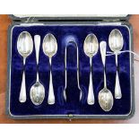A George V set of six silver tea spoons with a pair of sugar tongs,
