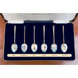 A boxed mint set of silver gilt teaspoons, enamelled with flowers,