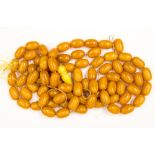 A bag of loose butterscotch amber type beads, each bead measuring approx 23 mm by 13 mm,