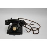 A 1940s, 200 series black Bakelite telephone with blanked dial,