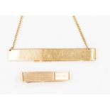 A 14k yellow gold tie slide with a chain detail,