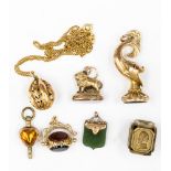 A collection of five pendant charms including a 9ct gold tri stone fob;
