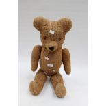 A circa 1940s, jointed straw filled Teddy Bear,