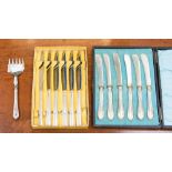 A boxed set of six butter knives with filled silver handles and a sardine fork with filled handle,