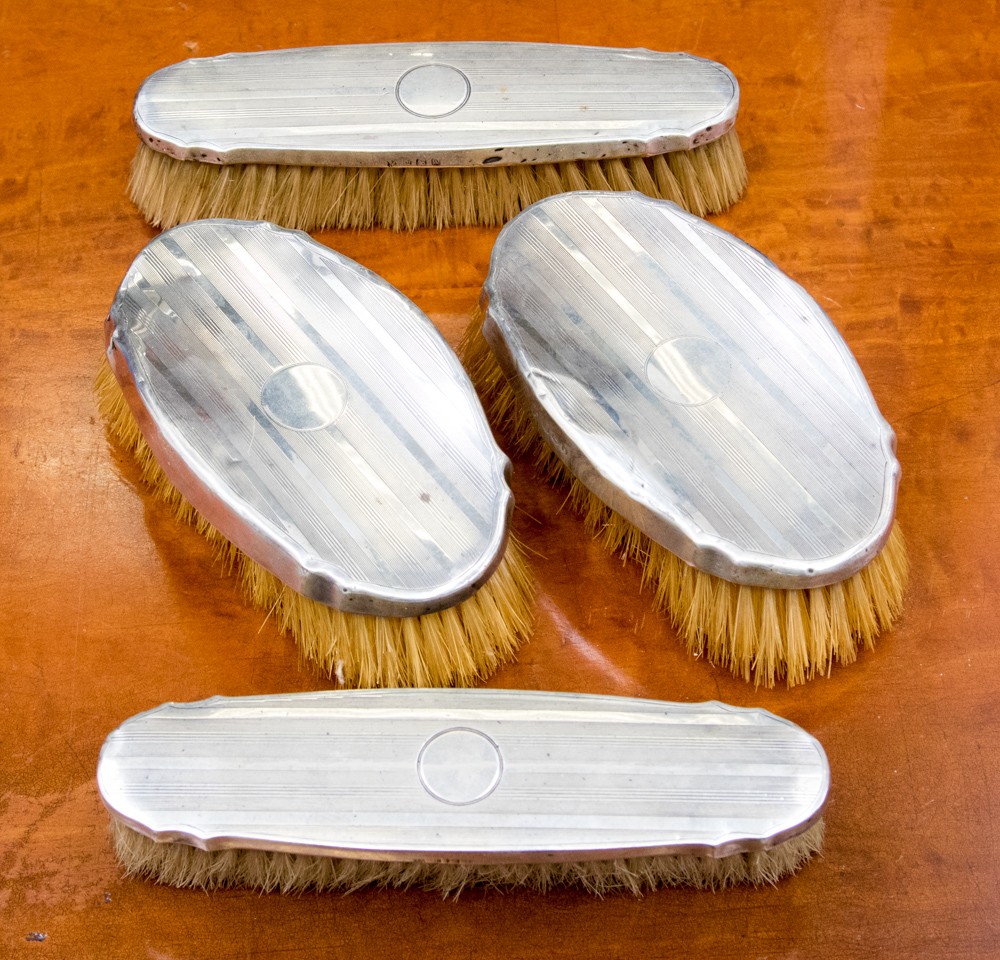 An Art Deco silver backed brush set, engine turned design,