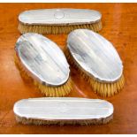 An Art Deco silver backed brush set, engine turned design,