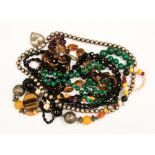 A collection of bead necklaces including malachite, a quartz strand,