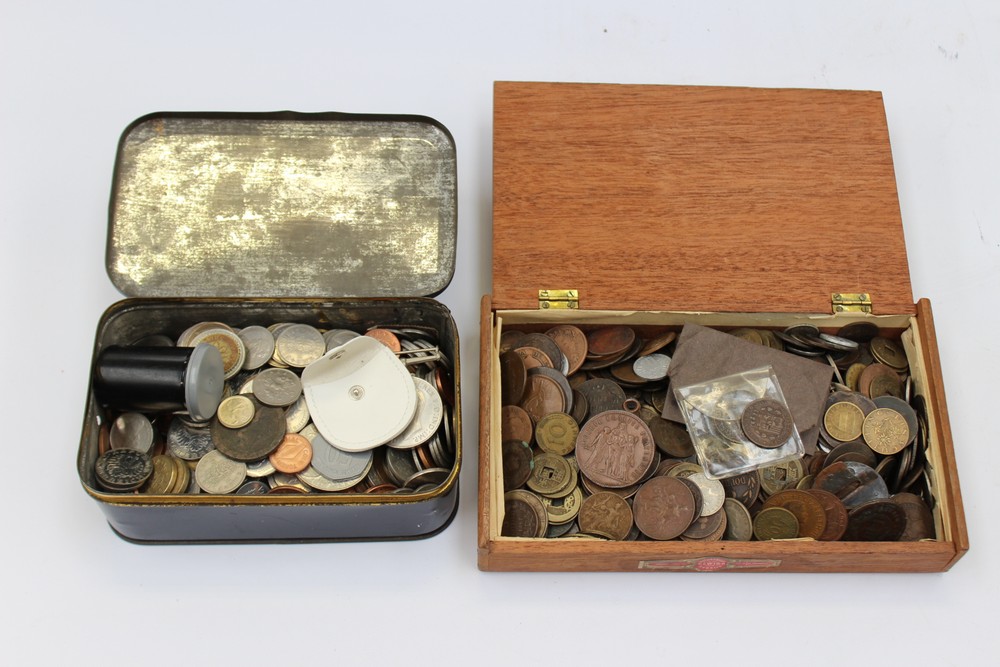A tin and wooden box of various coins,