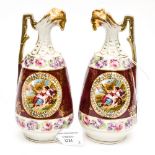 A pair of small continental porcelain decorative ewers with transfer and painted central design