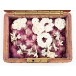A Victorian box containing a collection of Parian brooches,