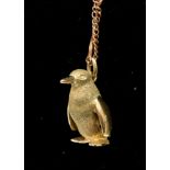 A 9ct yellow gold penguin pendant approx 20mm tall on a rose gold twist and chain link necklace,