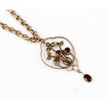 An Edwardian 9ct gold garnet and seed pearl pendant with foliate detail with three round garnets